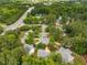 Wide aerial view showcasing lush green neighborhood with mature trees, community pool and road access at 106 Fawley Ct, Cary, NC 27519