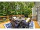 Inviting back deck featuring outdoor seating surrounded by lush trees and a wooden railing at 106 Fawley Ct, Cary, NC 27519