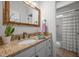 Bathroom featuring granite counters, decorative mirror, and shower with curtain in neutral tones at 106 Fawley Ct, Cary, NC 27519