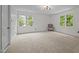 Spacious bedroom with neutral walls, plush carpeting, and abundant natural light from large windows at 106 Fawley Ct, Cary, NC 27519
