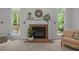 Living room fireplace with decorative mantle, brick surround, and bright windows create a cozy atmosphere at 106 Fawley Ct, Cary, NC 27519