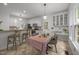 Open kitchen with breakfast bar, dining table, and white cabinetry offers a welcoming and functional space at 106 Fawley Ct, Cary, NC 27519
