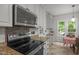 Well-lit kitchen features stainless steel appliances, granite countertops, and a dining area with backyard access at 106 Fawley Ct, Cary, NC 27519