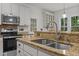 Modern kitchen with stainless steel appliances, granite countertops, and ample cabinetry, perfect for culinary enthusiasts at 106 Fawley Ct, Cary, NC 27519