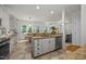 Bright, open kitchen with granite countertops, tile flooring, and stainless steel appliances overlooking the dining area at 106 Fawley Ct, Cary, NC 27519