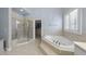 A luxurious bathroom features tile flooring, a glass shower, and a garden tub for relaxation at 106 Painted Turtle Ln, Cary, NC 27519