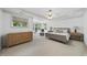Spacious bedroom featuring tray ceilings, neutral carpet, a sitting area, and large windows offering natural light at 106 Painted Turtle Ln, Cary, NC 27519