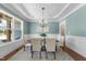 Elegant dining room featuring wainscoting, a chandelier, and natural light streaming through the window at 106 Painted Turtle Ln, Cary, NC 27519