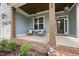 Inviting front porch with stylish seating, wooden columns, and charming brick accents at 106 Painted Turtle Ln, Cary, NC 27519
