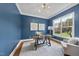 Stylish home office with a dark blue accent wall, a modern desk, and ample natural light at 106 Painted Turtle Ln, Cary, NC 27519