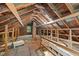 Exposed beams and wood create a rustic feel in the unfinished attic space of this home at 1105 Hawthorne Ln, Burlington, NC 27215