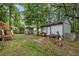 Spacious backyard featuring lush greenery, outbuilding, and entertainment area with a red tricycle at 1105 Hawthorne Ln, Burlington, NC 27215