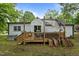 Back exterior of a home featuring a deck, and lush trees in the backyard at 1105 Hawthorne Ln, Burlington, NC 27215