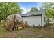 Back exterior featuring a deck with stairs, lush trees in the backyard, and gray roof at 1105 Hawthorne Ln, Burlington, NC 27215