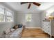 Bedroom with hardwood floors, two windows, ceiling fan, and a white painted dresser at 1105 Hawthorne Ln, Burlington, NC 27215