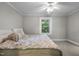 Comfortable bedroom with soft carpet, ceiling fan, and a large window at 1105 Hawthorne Ln, Burlington, NC 27215