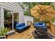 Back deck with patio furniture, grill, and an umbrella. Lush trees in the background at 1105 Hawthorne Ln, Burlington, NC 27215