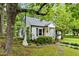 Charming cottage-style house with black shutters, a small front porch, and mature trees at 1105 Hawthorne Ln, Burlington, NC 27215