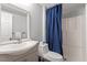 Cozy bathroom features a modern sink and vanity, toilet, and shower with blue shower curtain at 1109 Buckingham Rd, Garner, NC 27529