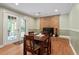 Bright dining area features french doors, brick fireplace, and wood floors at 1109 Buckingham Rd, Garner, NC 27529