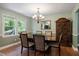 Formal dining room featuring a chandelier, hardwood floors, a large window, and a decorative wood cabinet at 1109 Buckingham Rd, Garner, NC 27529