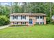 Charming split-level home featuring a brick facade, well-manicured lawn, and mature trees at 1109 Buckingham Rd, Garner, NC 27529