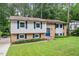 Charming split-level home featuring a brick facade, well-manicured lawn, and mature trees at 1109 Buckingham Rd, Garner, NC 27529