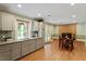 Modern kitchen leads to dining area with brick fireplace and wood floors at 1109 Buckingham Rd, Garner, NC 27529