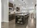 Open-concept kitchen showcasing a center island with seating, dark cabinets, and modern lighting fixtures at 118 Manning Way, Durham, NC 27703