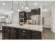 Bright kitchen with a center island, stainless steel refrigerator, and sleek dark wood cabinets at 118 Manning Way, Durham, NC 27703