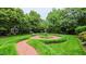 Lush backyard with a brick walkway, gazebo, and beautiful landscaping at 119 Georgetowne Dr, Elon, NC 27244