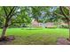 Spacious backyard with a brick patio, mature trees, and well-manicured lawn at 119 Georgetowne Dr, Elon, NC 27244