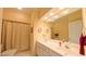 Bathroom featuring a shower with curtain, double sink vanity, and large mirror at 119 Georgetowne Dr, Elon, NC 27244
