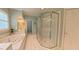 Bright bathroom featuring a soaking tub, glass enclosed shower, and white tiled floor at 119 Georgetowne Dr, Elon, NC 27244