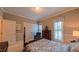 Bedroom featuring a four poster bed, sitting chair, and multiple windows with plantation shutters at 119 Georgetowne Dr, Elon, NC 27244