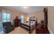 Bedroom featuring a four poster bed, sitting chair, and multiple windows with plantation shutters at 119 Georgetowne Dr, Elon, NC 27244