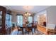 Elegant dining room with decorative chandelier, wooden table, and large windows providing natural light at 119 Georgetowne Dr, Elon, NC 27244