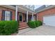 Inviting front entrance with brick steps and manicured greenery leading to the home at 119 Georgetowne Dr, Elon, NC 27244