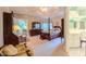 Bright main bedroom showcases a four-poster bed, carpeted floors, and views into the sunroom at 119 Georgetowne Dr, Elon, NC 27244