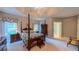 Bright main bedroom boasts tray ceilings, a four-poster bed, and a glimpse into the en suite bathroom at 119 Georgetowne Dr, Elon, NC 27244