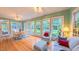 Open sunroom boasts a breakfast table, abundant windows, and natural light overlooking the outdoor scenery at 119 Georgetowne Dr, Elon, NC 27244
