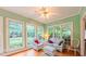 Bright sunroom featuring a ceiling fan and multiple windows offering abundant natural light at 119 Georgetowne Dr, Elon, NC 27244