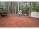 Spacious backyard with mature trees, playhouse, storage shed, and wooden deck area at 12 Striding Ridge Ct, Durham, NC 27713