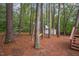 Private backyard with mature trees, a playset, and storage shed, ideal for outdoor activities at 12 Striding Ridge Ct, Durham, NC 27713