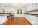 Stylish kitchen/dining area featuring white cabinetry, hardwood floors and a cozy breakfast bar with bar stool seating at 12 Striding Ridge Ct, Durham, NC 27713