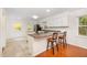 Eat-in kitchen featuring granite countertops, white cabinets, stainless appliances, breakfast bar, and bright natural light at 12 Striding Ridge Ct, Durham, NC 27713