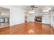 Open-concept living room with hardwood floors, a brick fireplace, built-in shelving, and seamless access to the kitchen at 12 Striding Ridge Ct, Durham, NC 27713