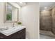 Bathroom featuring a vanity with drawers, mirror, and a shower with tan tiling and a pebbled floor at 120 Jo Anne Cir, Cary, NC 27513