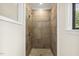 Bathroom shower with mosaic stone floors and horizontally laid tan tiles, bordered with a decorative tile band at 120 Jo Anne Cir, Cary, NC 27513