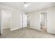 Spacious bedroom featuring neutral carpet, ceiling fan, and three entryways with access to closets and bathrooms at 120 Jo Anne Cir, Cary, NC 27513